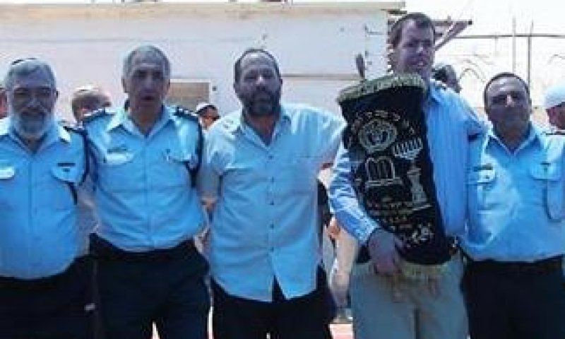 שוטרים ומתיישבים רוקדים יחד בחברון עם ספר התורה