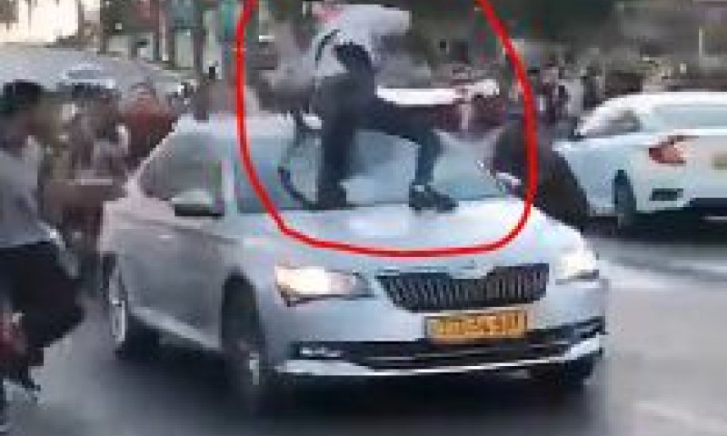 צפו: מפגינים מטפסים על רכב נוסע וחובטים בו