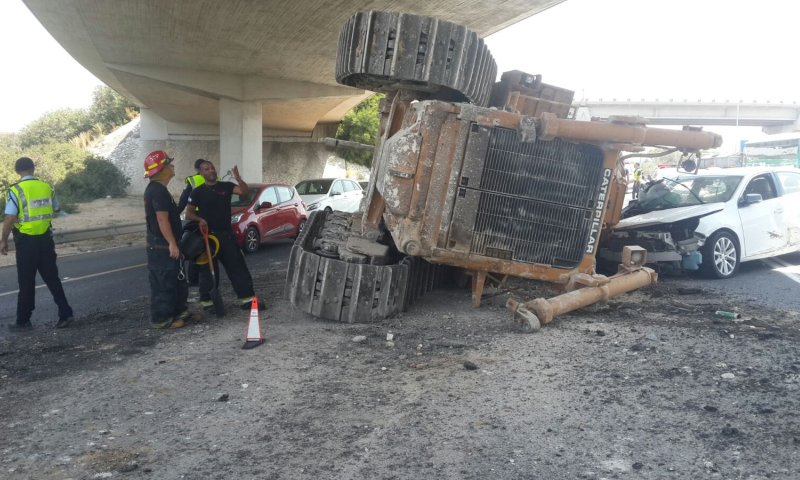 נס מתחת לגשר: טרקטור נפל ממשאית על מכונית
