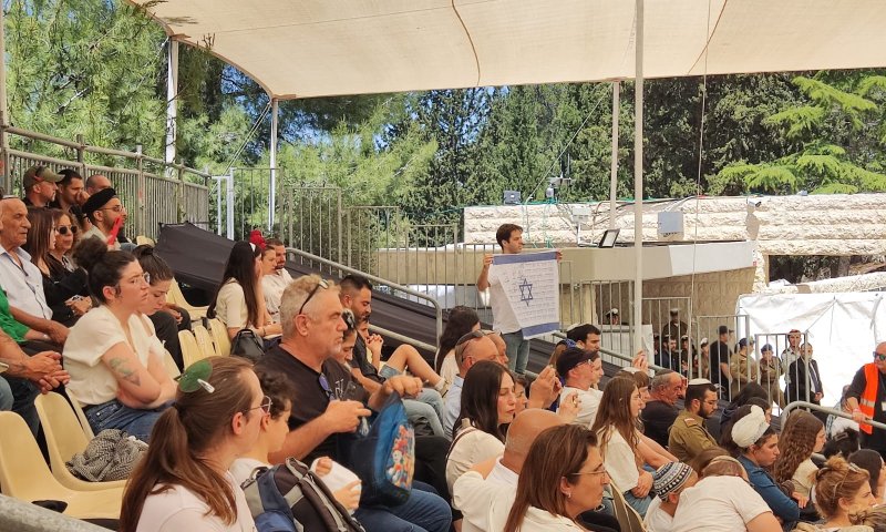 בזמן נאום נתניהו: מפגין הרים שלט מחאה